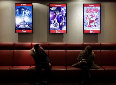 A couple look at a poster of the movie "Going Vertical" at a cinema in Moscow, Russia January 22, 2018. Picture taken January 22, 2018. REUTERS/Tatyana Makeyeva