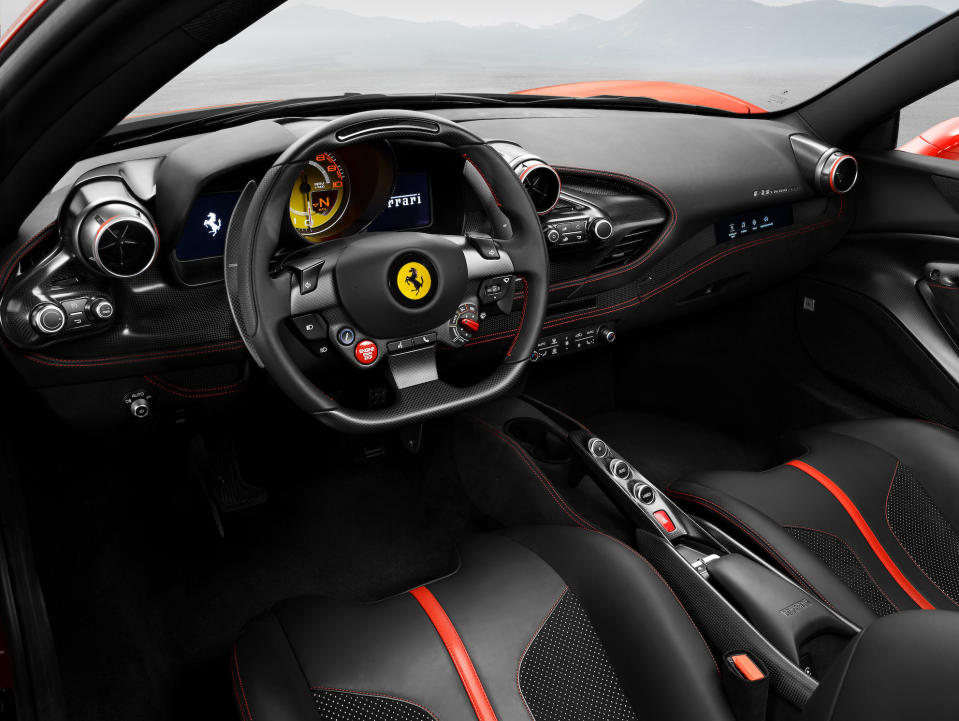 The dash and seats of a Ferrari F8 Tributo, in black leather with red and yellow accents