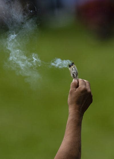 An Indigenous person smudges before the gathering to see Pope Francis on his visit to Maskwacis, Alta., during his visit to Canada. THE CANADIAN PRESS/Jason Franson