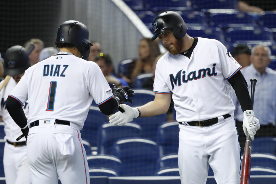 Miami Marlins' Austin Dean, right, congratulates Isan Diaz (1) after Diaz scored on a single by Lewis Brinson during the fourth inning of a baseball game against the Milwaukee Brewers, Thursday, Sept. 12, 2019, in Miami. (AP Photo/Wilfredo Lee)