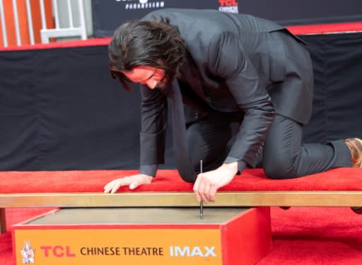 Keanu Reeves signs his name in fresh cement in front of the TCL Chinese Theatre in Los Angeles on May 14, 2019