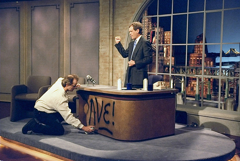 Bill Murray spray paints Dave's desk on the first taping of "The Late Show with David Letterman" August 30, 1993 on the CBS Television Network. Photo: Alan Singer/CBS ©1993 CBS Broadcasting Inc.