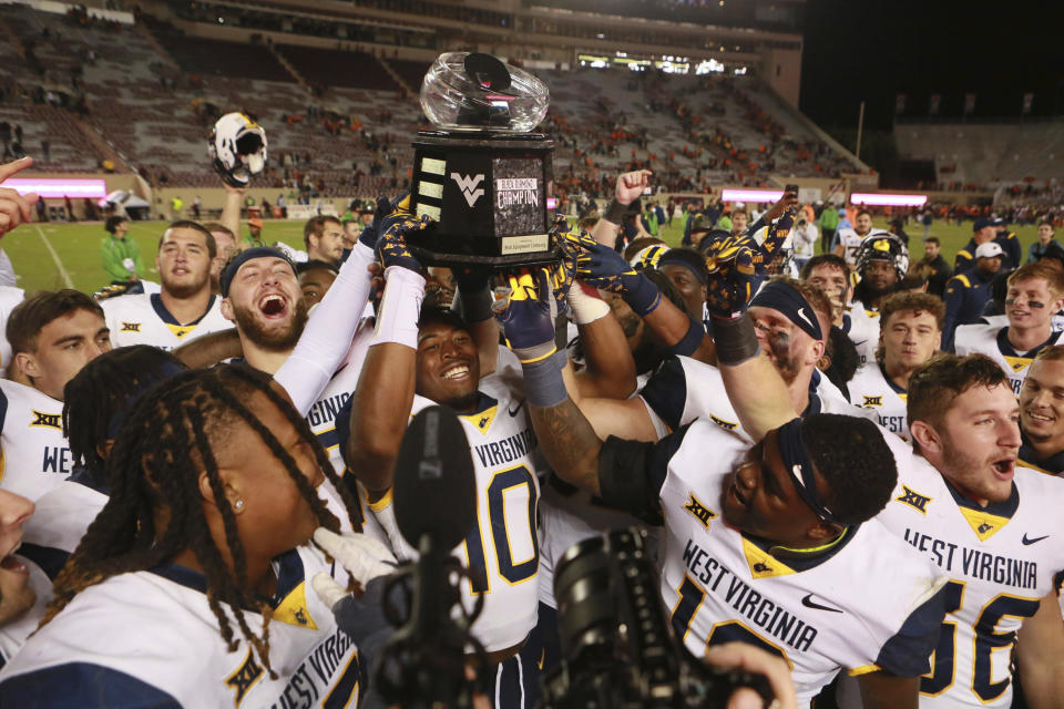 West Virginia players celebrate with the Black Diamond trophy after the team's win over Virginia Tech in an NCAA college football game Thursday, Sept. 22, 2022, in Blacksburg, Va. (Matt Gentry/The Roanoke Times via AP)