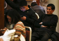 Familiares de los pasajeros a bordo del avión desaparecido de Malaysia Airlines, esperan por las útlimas noticias en un hotel en Beijing, China, este jueves 13 de marzo de 2014.(AP Photo/Vincent Thian)