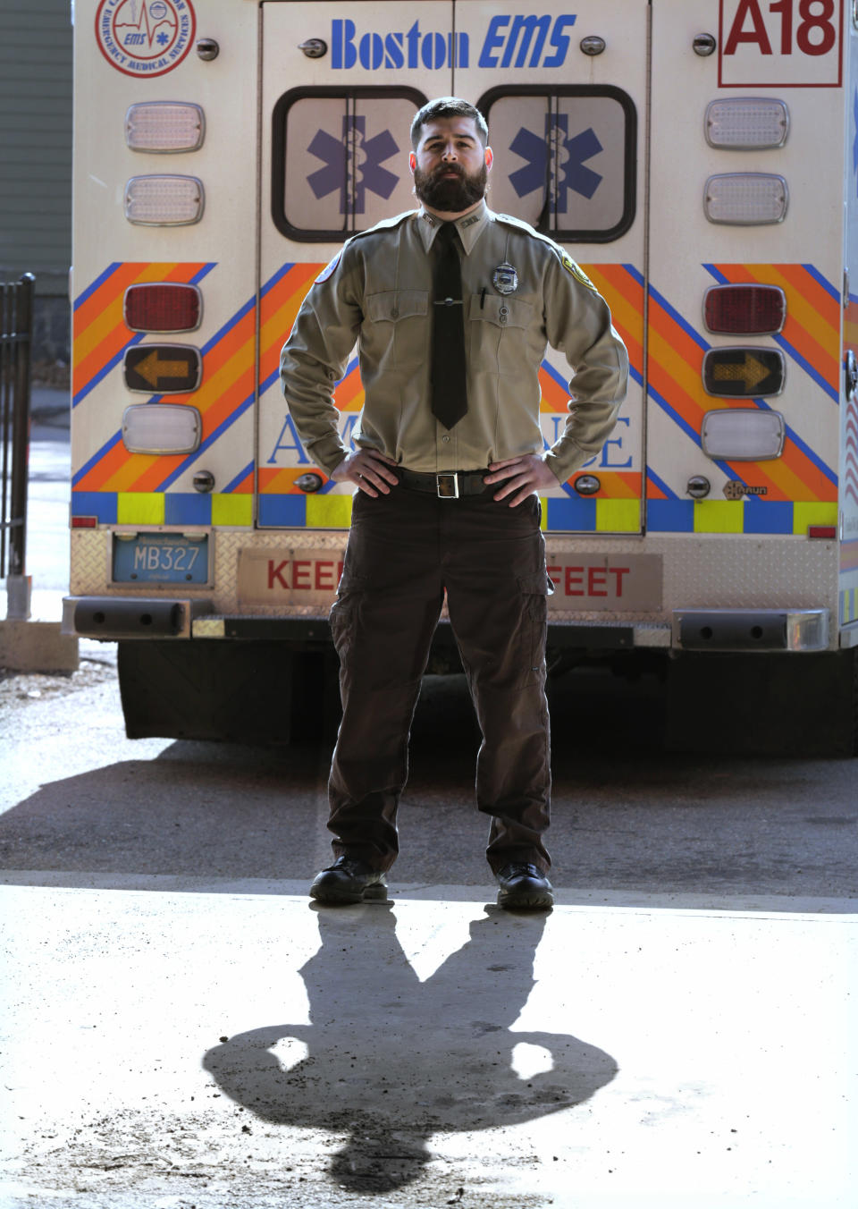 In this Thursday, March 20, 2014 photo, Boston Emergency Medical Services EMT Paul Mitchell stands next to an ambulance at his station in the Hyde Park neighborhood of Boston. Mitchell, along with bystander Carlos Arredondo and volunteer Devin Wang, are credited with helping to save the life of Jeff Bauman, who suffered traumatic injuries in the Boston Marathon bombings. (AP Photo/Charles Krupa)