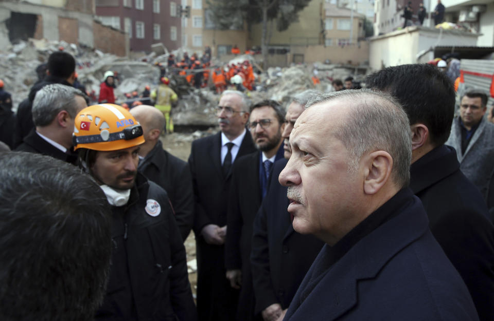 Turkey's President Recep Tayyip Erdogan speaks to people as he visits the site of a collapsed building in Istanbul, Saturday, Feb. 9, 2019. Erdogan says there are "many lessons to learn" from the collapse of a residential building in Istanbul where at least 17 people have died.(Presidential Press Service via AP, Pool)