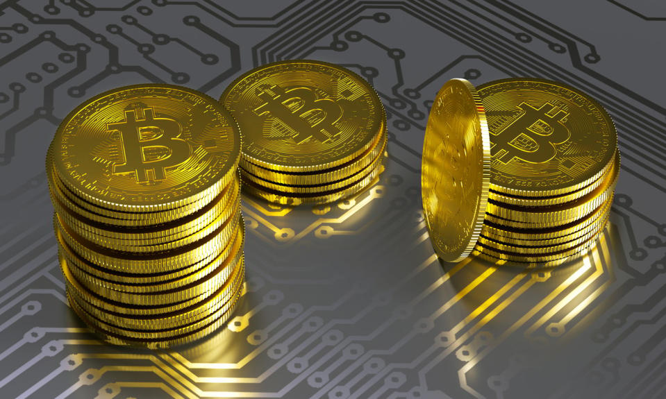 Coins with Bitcoin logo on a circuit board.