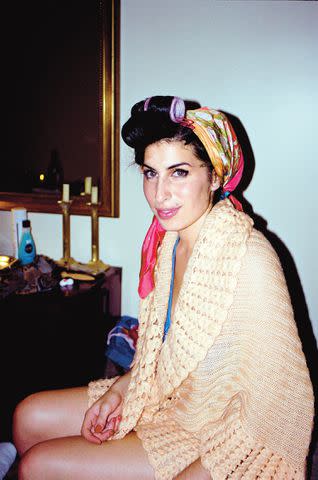 <p>Charles Moriarty / Iconic Images</p> A candid photo of Winehouse wearing curlers and scarf, taken by Moriarty during their second photoshoot in New York in 2003.