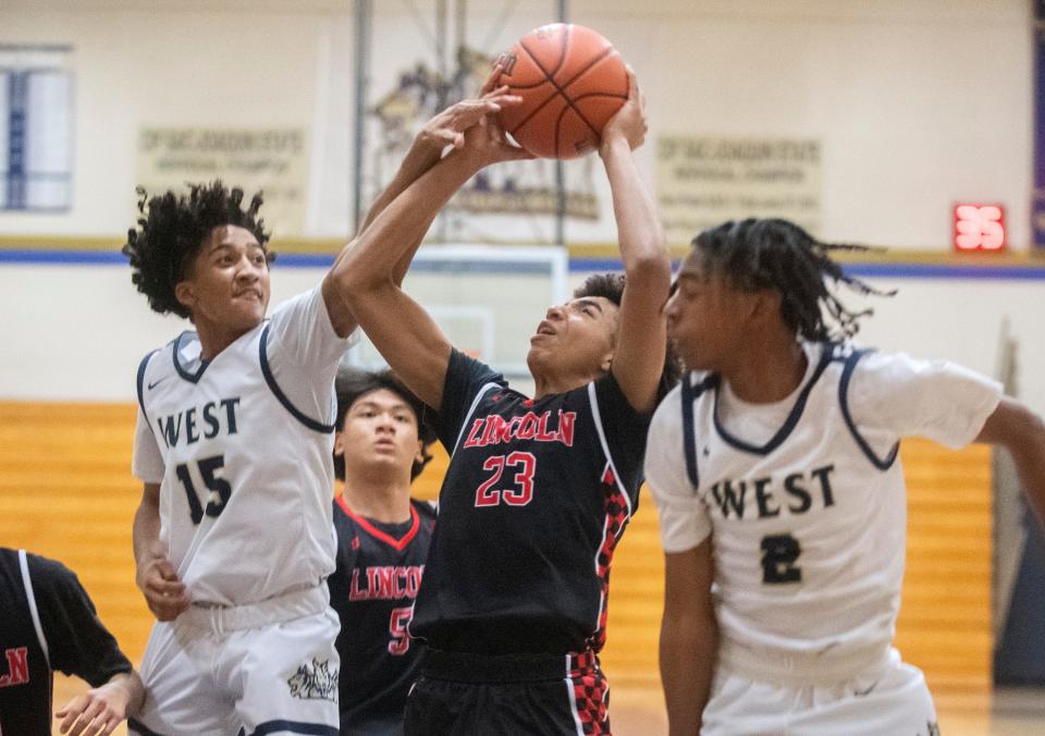 Lincoln's Quentin Thompson, center, goes to the hoop against West's Xavier Cardona Renshaw, left and Cameron Williams during a boys varsity basketball game at West High in Tracy on Friday, Jan. 27, 2023. Lincoln won 59-27. 