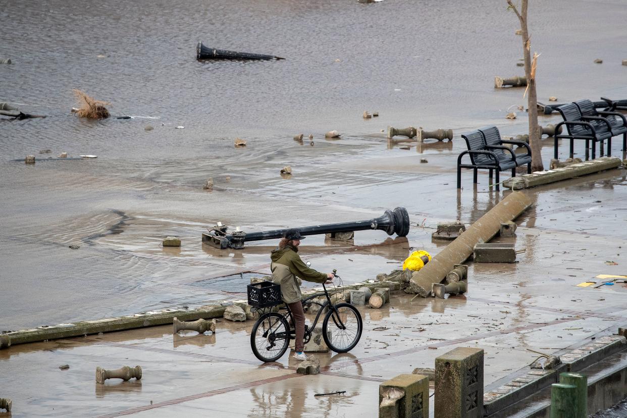 A person stopped on his bike looking at the damage in flooded Centennial Park in Fort Myers, Fla.