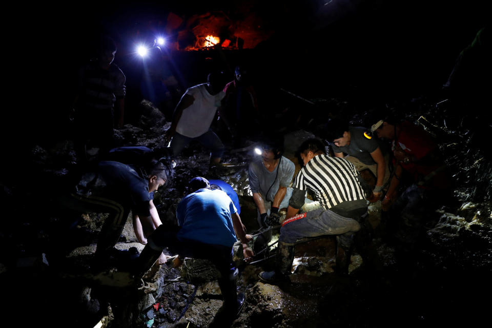 <p>Rescuers search for miners from the rubble of a bunkhouse after a landslide caused by Typhoon Mangkhut at a small-scale mining camp in Itogon, Benguet, in the Philippines, on Sept. 17, 2018.<br>(Photo by Erik De Castro, Reuters) </p>