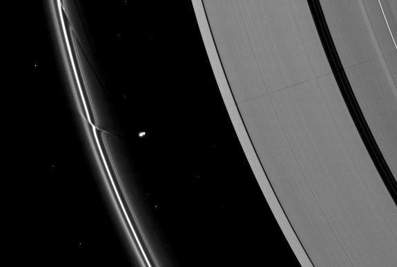 The effects of the small moon Prometheus loom large on two of Saturn's rings in this image taken a short time before Saturn's August 2009 equinox. A long, thin shadow cast by the moon stretches across the A ring on the right. The gravity of po