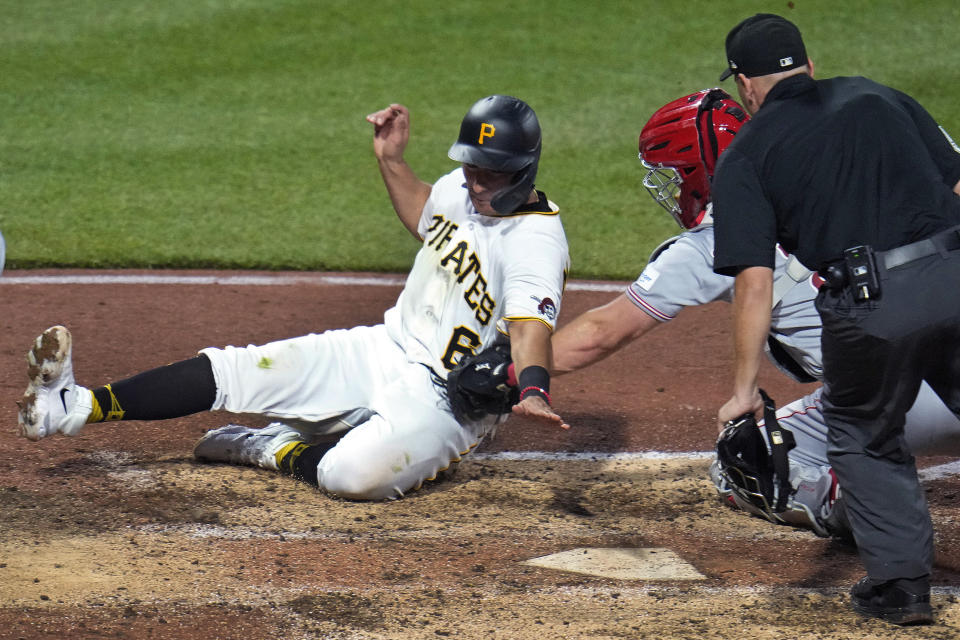Pittsburgh Pirates' Mark Mathias (6) is tagged out by Cincinnati Reds catcher Tyler Stephenson while attempting to score on a single by Austin Hedges during the sixth inning of a baseball game in Pittsburgh, Friday, April 21, 2023. The umpire is Jansen Visconti. (AP Photo/Gene J. Puskar)