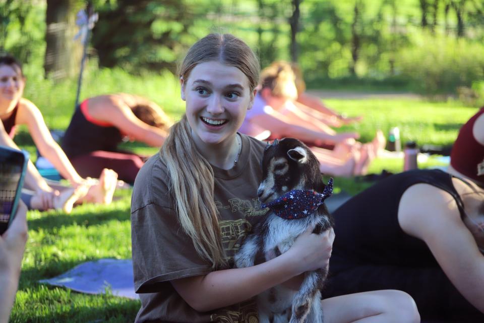 Isabella Krenik poses with a kid goat during a Bee Fit goat yoga session Thursday, June 16.