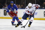 Washington Capitals' Alex Ovechkin (8) controls the puck while New York Rangers' Ryan Reaves (75) trails the play during the first period of an NHL hockey game Thursday, Feb. 24, 2022, in New York. (AP Photo/John Munson)