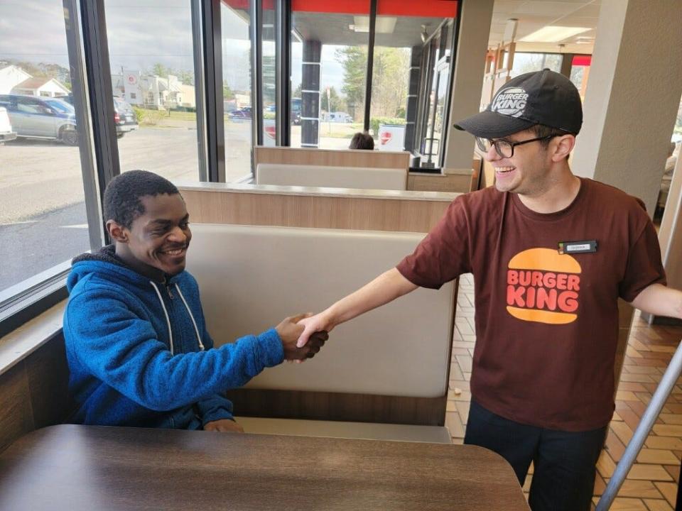 Jaden, left, celebrates reaching one of his goals by finding employment at Burger King with friend and co-worker Andrew. Last names of the individuals not provided by Emory Valley Center.