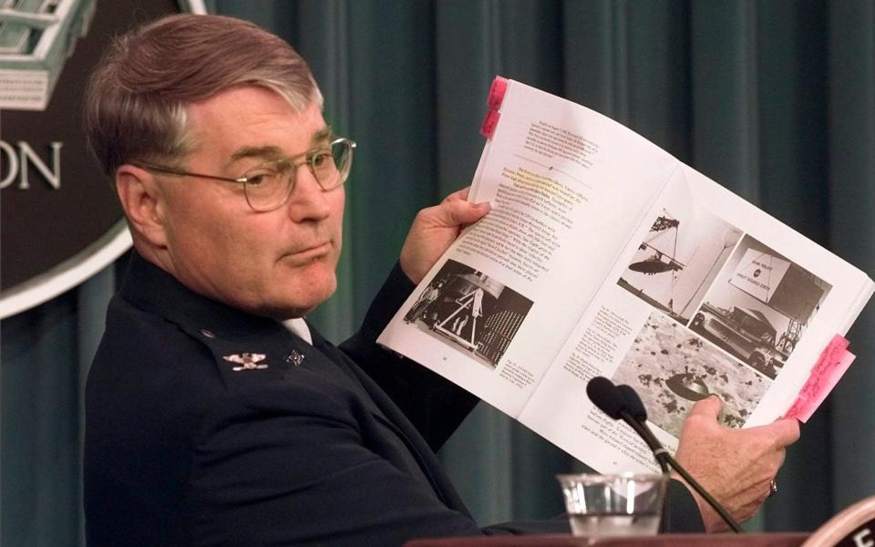 Col. John Haynes holds a copy of The Roswell Report during a Pentagon news conference in 1997 - Susan Walsh/AP