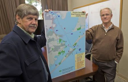 Jim Blackburn (L), professor of Environmental Law, and Philip Bedient (R), professor of Civil and Environmental Engineering at the Rice University School of Engineering; pose with a Houston Galveston Area Protection System (HGAPS) map at the school in Houston, Texas November 21, 2014. REUTERS/Richard Carson