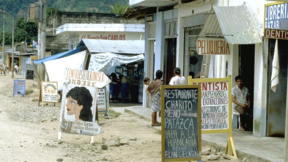 Carteles de tiendas y una calle en Pichanaki