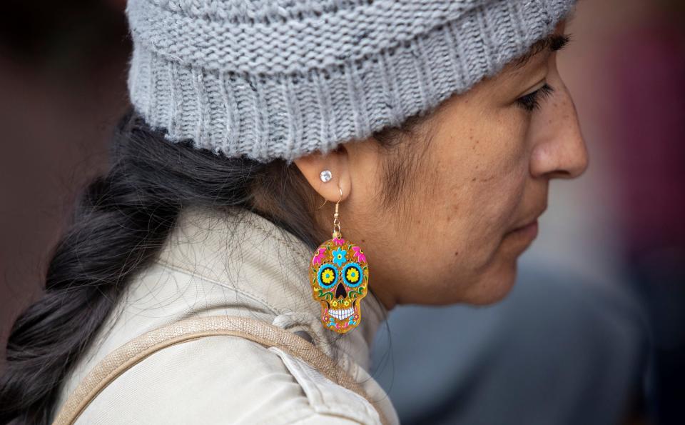 A Detroit resident wears colorful skull earrings during a Dia de los Muertos event organized by the Detroit Riverfront Conservancy at the Robert C. Valade Park in Detroit on Saturday, Oct. 28, 2023.