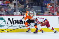 Philadelphia Flyers' Scott Laughton, left, and New Jersey Devils' Jack Hughes chase after the puck during the second period of an NHL hockey game, Saturday, Dec. 3, 2022, in Philadelphia. (AP Photo/Matt Slocum)