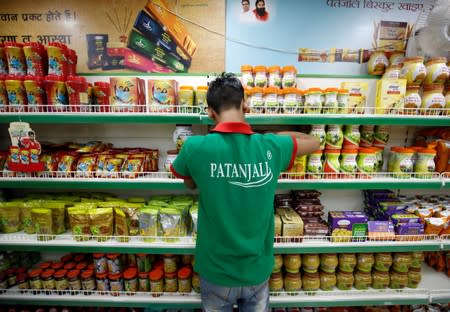 A worker arranges consumable goods inside a Patanjali store in Ahmedabad