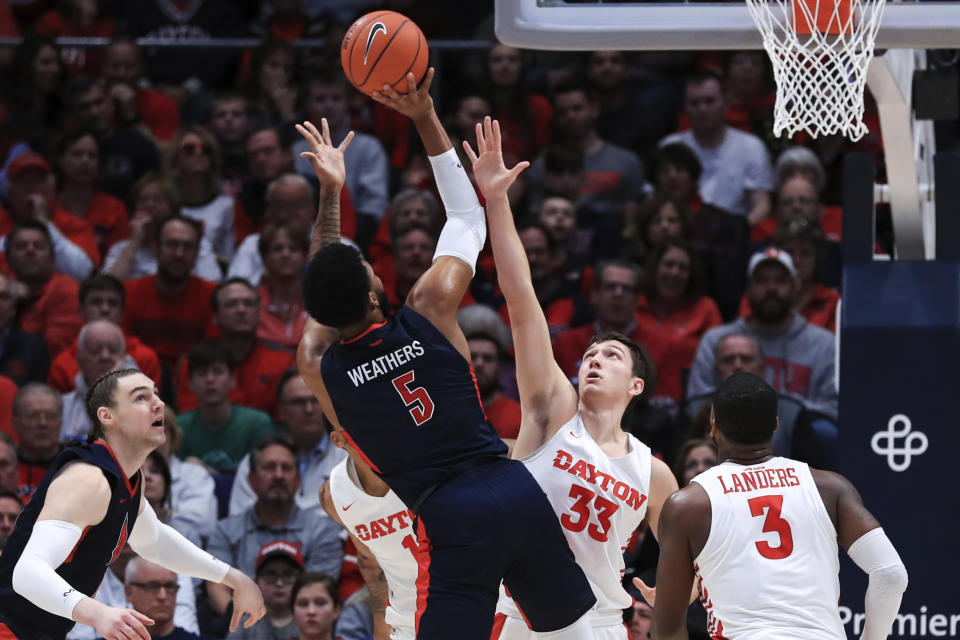 Duquesne's Marcus Weathers (5) takes a shot against Dayton's Ryan Mikesell (33) in the first half of an NCAA college basketball game, Saturday, Feb. 22, 2020, in Dayton, Ohio. (AP Photo/Aaron Doster)