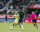 New York Red Bulls midfielder Emil Forsberg, left, fights for the ball with Vancouver Whitecaps defender Javain Brown (23) during an MLS soccer match, Saturday, April 27, 2024, in Harrison, N.J. (AP Photo/Stefan Jeremiah)