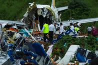 Officials inspect the wreckage of an Air India Express jet at Calicut International Airport in Karipur, Kerala, on August 8, 2020. - Fierce rain and winds lashed a plane carrying 190 people before it crash-landed and tore in two at an airport in southern India, killing at least 18 people and injuring scores more, officials said on August 8. (Photo by Arunchandra BOSE / AFP) (Photo by ARUNCHANDRA BOSE/AFP via Getty Images)