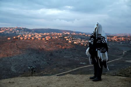 A Jewish man covered in a prayer shawl, prays in the Jewish settler outpost of Amona in the West Bank December 18, 2016. REUTERS/Baz Ratner