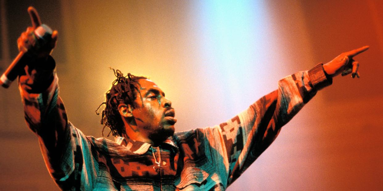 Coolio performs on a red-lit stage.