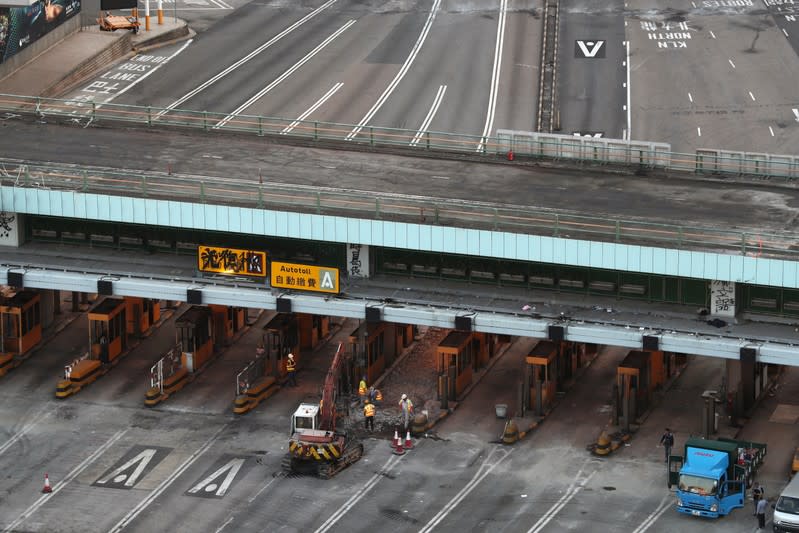 Workers are seen under the bridge above the Cross Harbour Tunnel outside Hong Kong Polytechnic University (PolyU), in Hong Kong