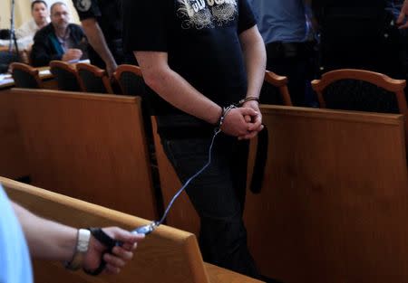 A defendant arrives in the courtroom after a break in a trial of men charged with causing the death of 71 migrants who suffocated in a lorry found beside an Austrian motorway in 2015, in Kecskemet, Hungary June 21, 2017. REUTERS/Bernadett Szabo