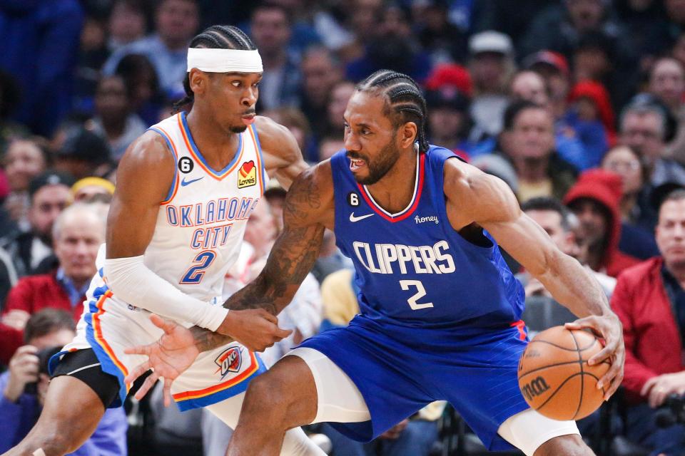 Los Angeles Clippers forward Kawhi Leonard, right, is defended by Oklahoma City Thunder guard Shai Gilgeous-Alexander during the first half of an NBA basketball game Tuesday, March 21, 2023, in Los Angeles. (AP Photo/Ringo H.W. Chiu)