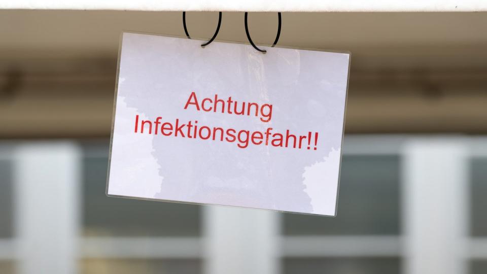 Ein Schild mit der Aufschrift «Achtung Infektionsgefahr!» an einem Johanniter-Zelt in Brandenburg.