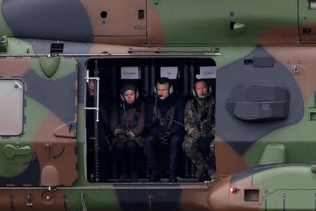 French President Emmanuel Macron (C), Minister of the Armed Forces Florence Parly (L) and General Jean-Pierre Bosser, Chief of Staff of the French land forces (chef d'etat-major de l'armee de terre, CEMAT), fly in a NH90 helicopter during a military exercise over the military camp of Suippes, near Reims, France, March 1, 2018. REUTERS/Yoan Volat/Pool/Files