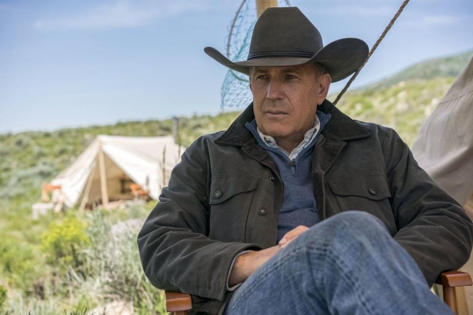 Kevin Costner sits in a chair as John Dutton in Yellowstone scene