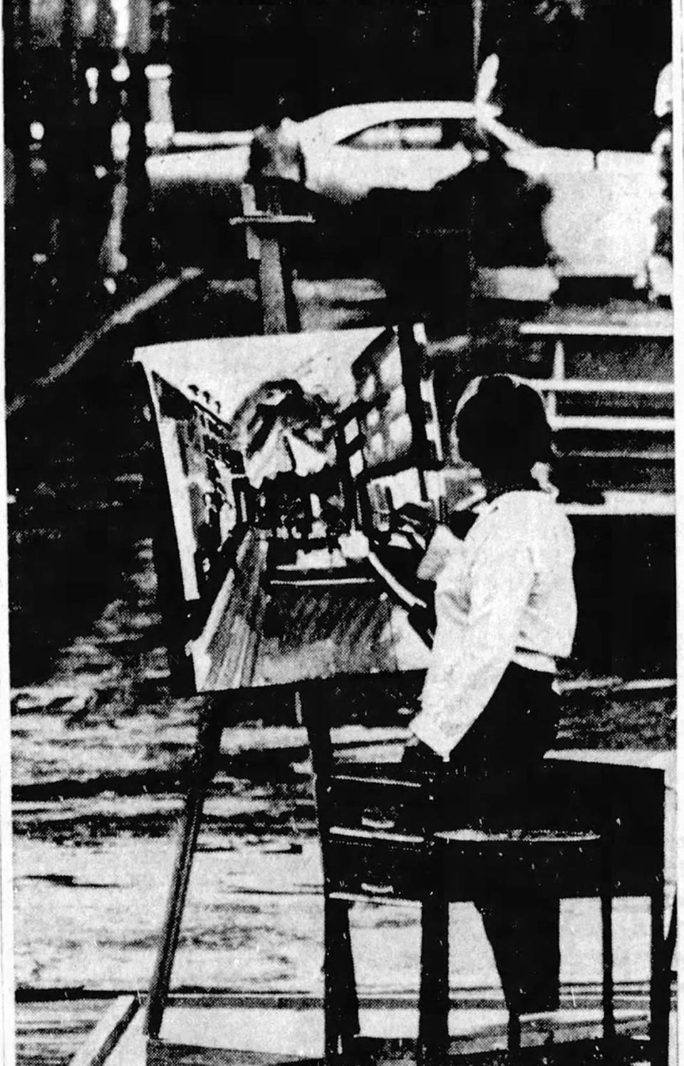 An artist braves the rain on South Allen Street during the Central Pennsylvania Festival of the Arts in 1967.