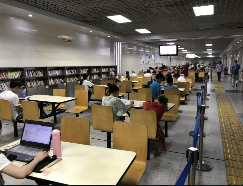 People reading at tables in a well-lit underground library space