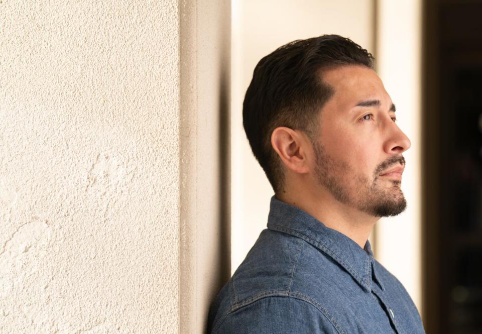 A man stands in front of a building on the Cal State Fresno campus.