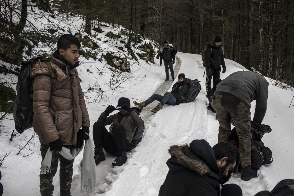 A group of Afghan migrants take a break as they walk through the mountains in an area believed to be littered with landmines planted during the Bosnian war as they attempt to cross the border into Croatia near Bihac, northwestern Bosnia on Dec. 15, 2019. (Photo: Manu Brabo/AP)