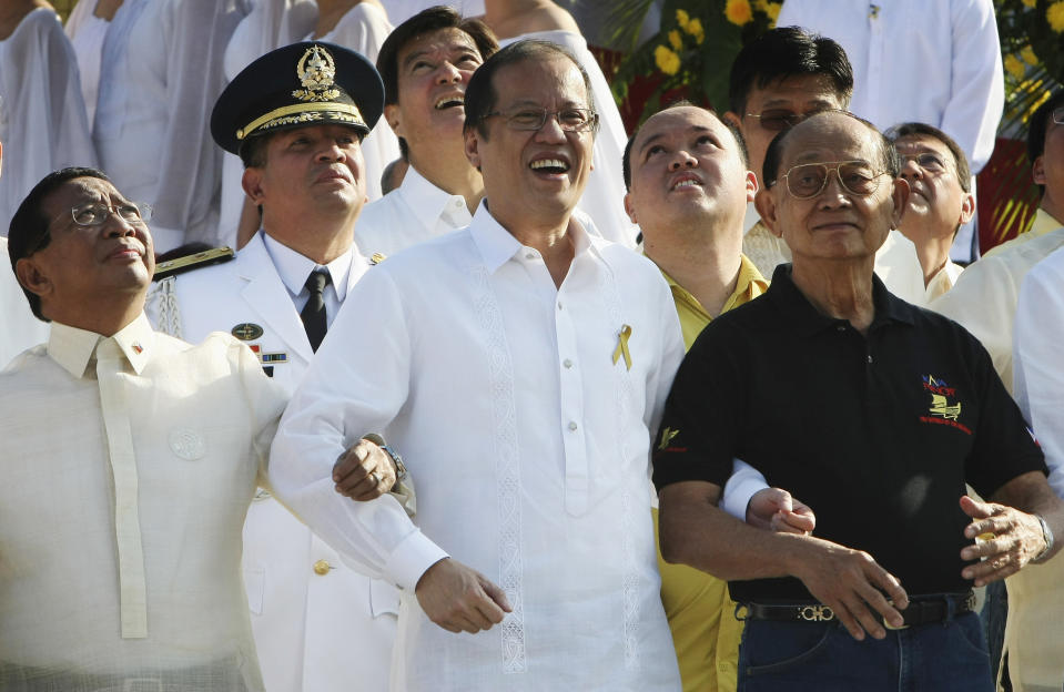 FILE - Philippine President Benigno Aquino III, center, Vice-President Jejomar Binay, left, and former President Fidel Ramos, right, link arms as they sing a patriotic song to celebrate the 25th "People Power" anniversary on Feb. 25, 2011, at the People Power Monument along EDSA highway at suburban Quezon city, northeast of Manila, Philippines. Ramos was one of the leaders of the near bloodless four-day people power revolution 25 years ago that ousted the late strongman Ferdinand Marcos from 20-year-rule and helped install Aquino's mother Corazon "Cory" Aquino to the presidency. (AP Photo/Bullit Marquez, File)