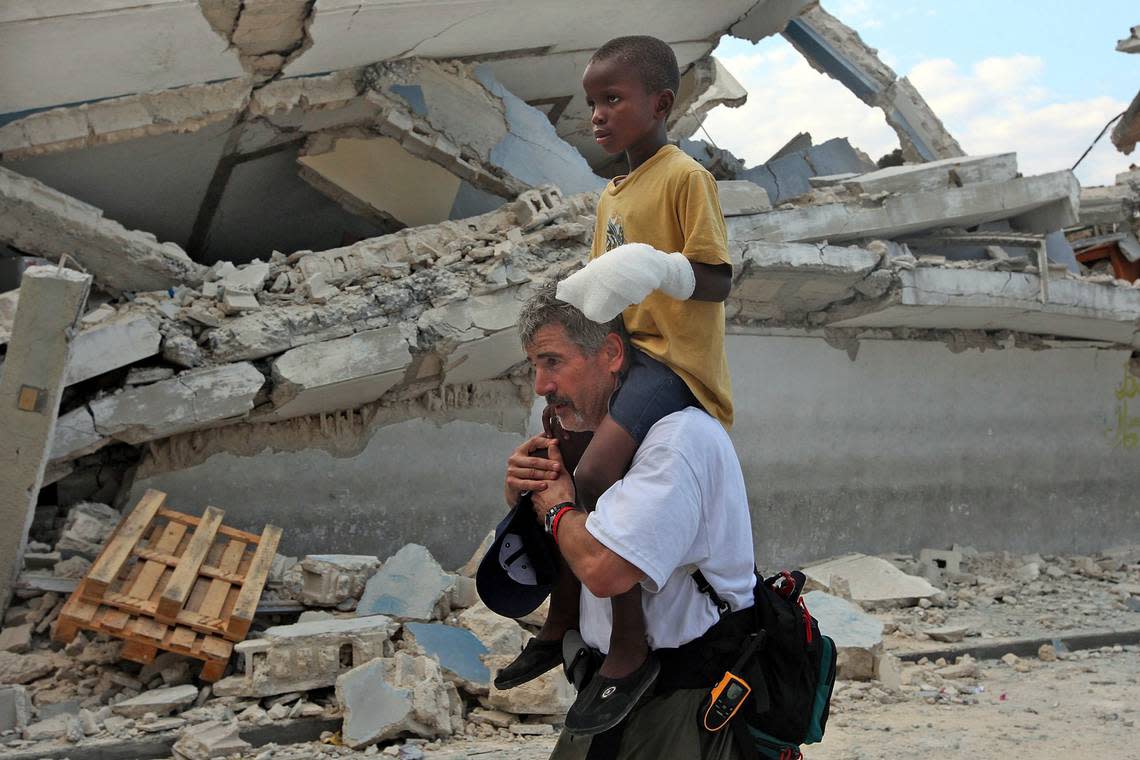 Duke University Medical School graduate Dr. Paul Averbach, of Stanford University carries a young boy on his shoulders to a surgery clinic where one of the boys fingers will be amputated. Averbach, teaches emergency medicine at Stanford and is volunteering his time to help victims of a devastating earthquake.