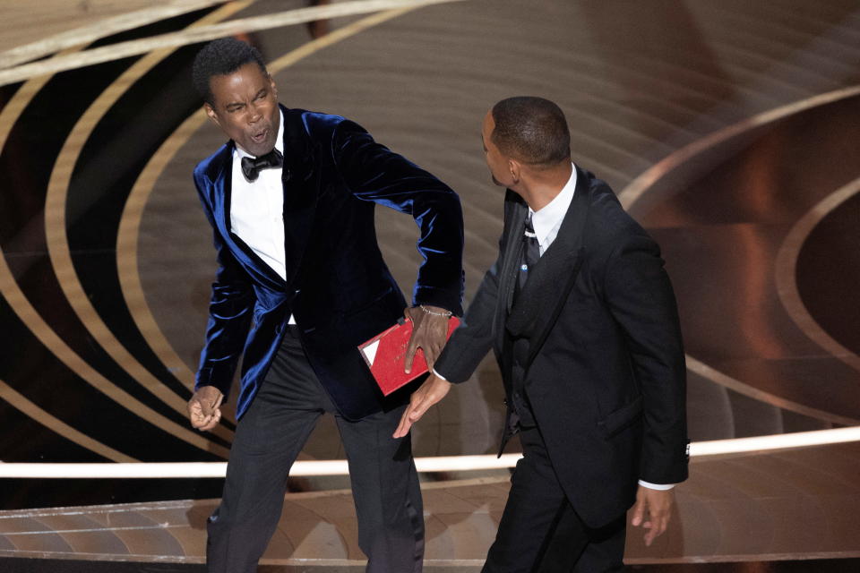 Chris Rock reacts after being hit by Will Smith (R) as Rock spoke on stage during the 94th Academy Awards in Hollywood, Los Angeles, California, U.S., March 27, 2022. Picture taken March 27, 2022. REUTERS/Brian Snyder BEST AVAILABLE QUALITY