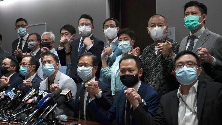 Hongkongs pro-demokratische Gesetzgeber halten vor einer Pressekonferenz im Legislativrat ihre Hände zusammen. Aus Protest gegen den Rauswurf von vier Abgeordneten aus dem Hongkonger Parlament haben ein Großteil der Mitglieder des demokratischen Lagers ihren Rücktritt angekündigt. Foto: dpa