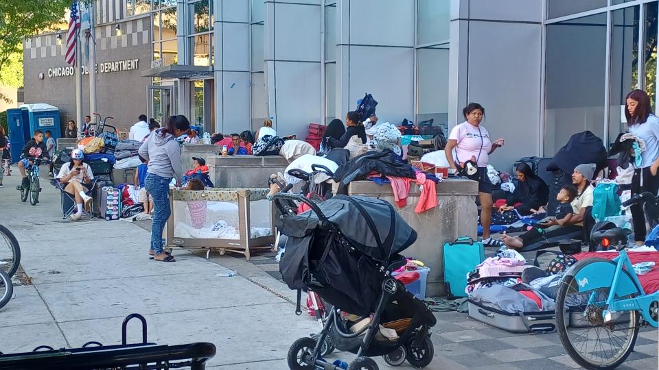 A row of asylum-seeking migrants camp outside the Chicago Police Department's District 1 headquarters. Chicago officials are looking to relocate migrants to base camps with heated tents or unused large facilities as they wait for spots in city-run shelters.