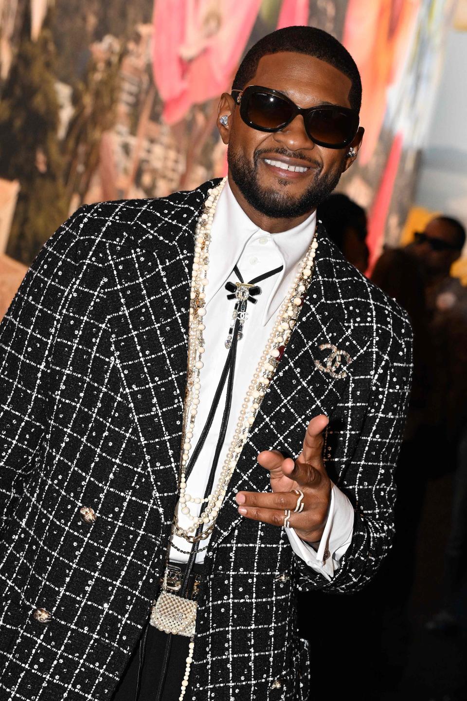 Usher gestures before the Chanel show during Paris Fashion Week at the Grand Palais Ephemere in Paris on Oct. 3, 2023.