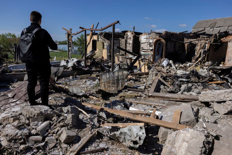 A man surveys the damage of a house that was hit during a Russian missile strike in the Kyiv region