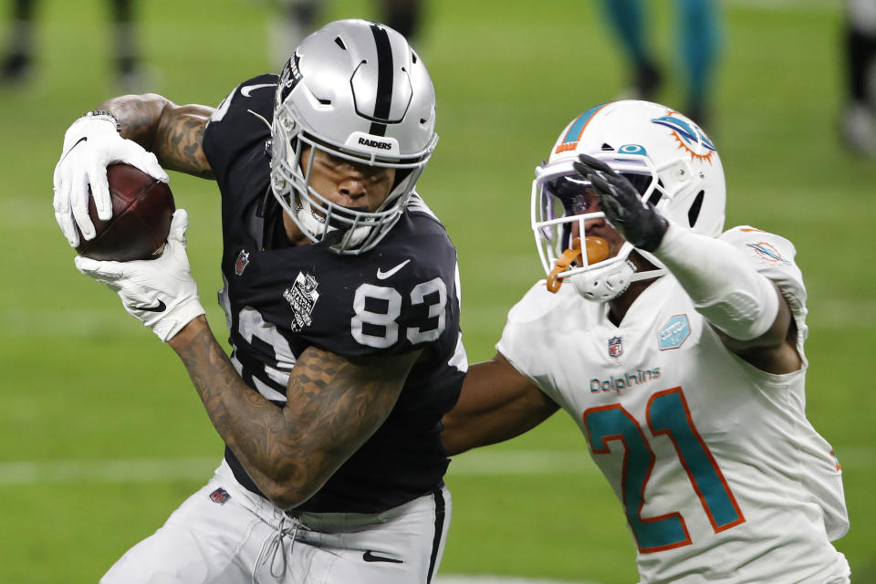 Las Vegas Raiders tight end Darren Waller (83) makes a catch over Miami Dolphins free safety Eric Rowe (21) during the first half of an NFL football game, Saturday, Dec. 26, 2020, in Las Vegas. (AP Photo/Steve Marcus)