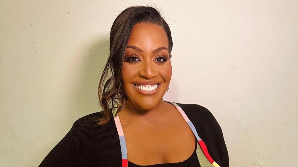 Alison Hammond smiles with her glossy hair tied into a neat, curled ponytail